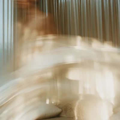 Sunlit neutral living room with sheer curtains and soft motion blur.